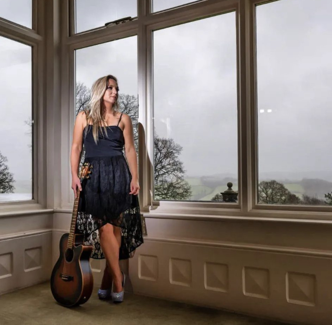 Laura Kate holding her guitar